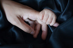 bébé qui tient la main de son papa